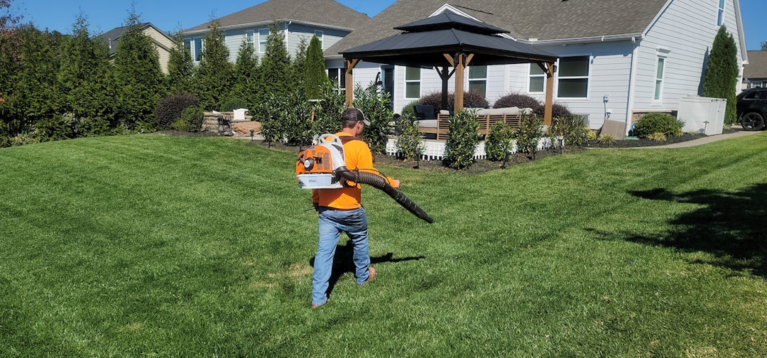 A man in an orange shirt holding a baseball bat